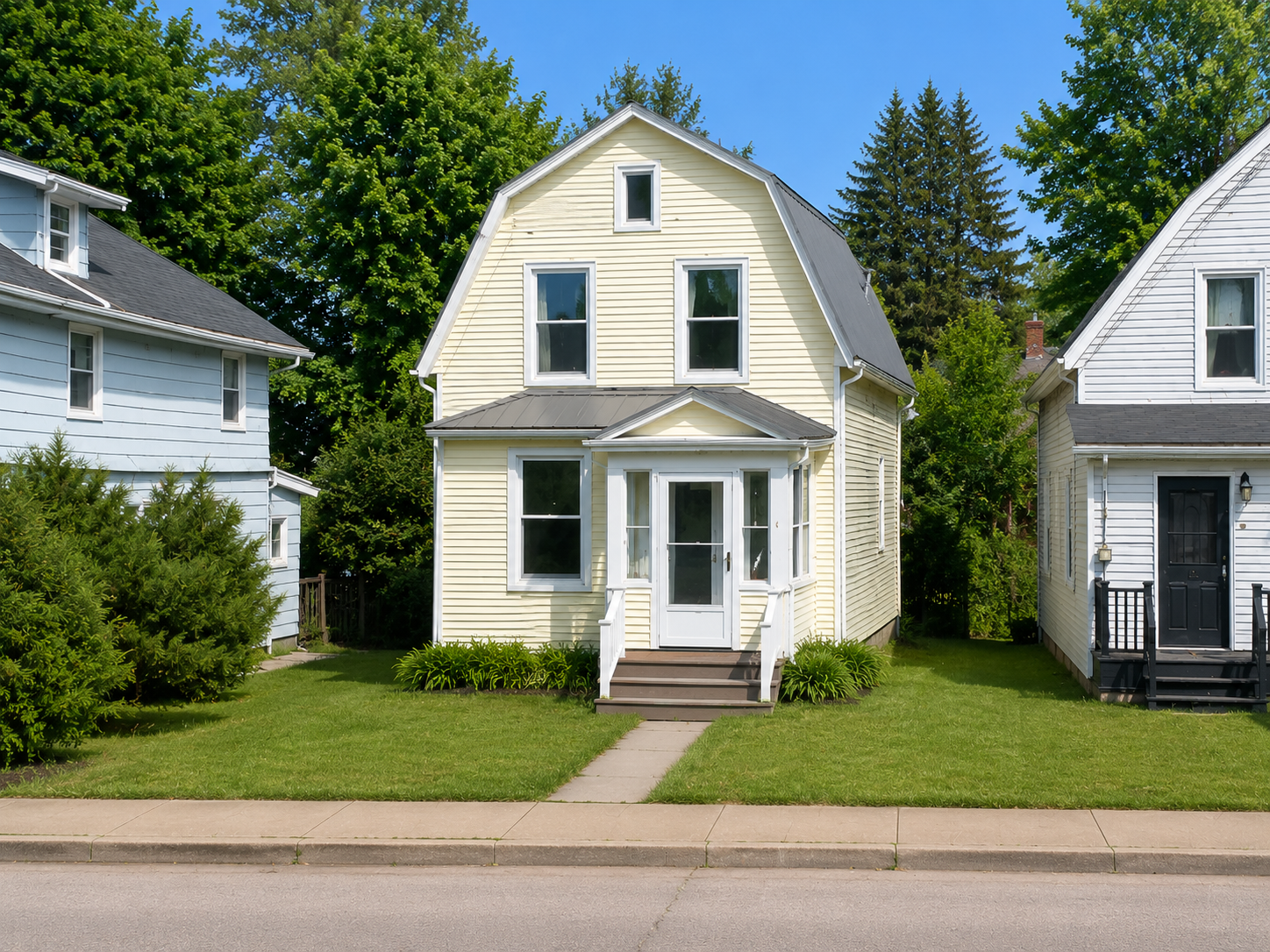 Two-storey pale yellow single-family home with white trim and a covered front entry on a quiet residential street.